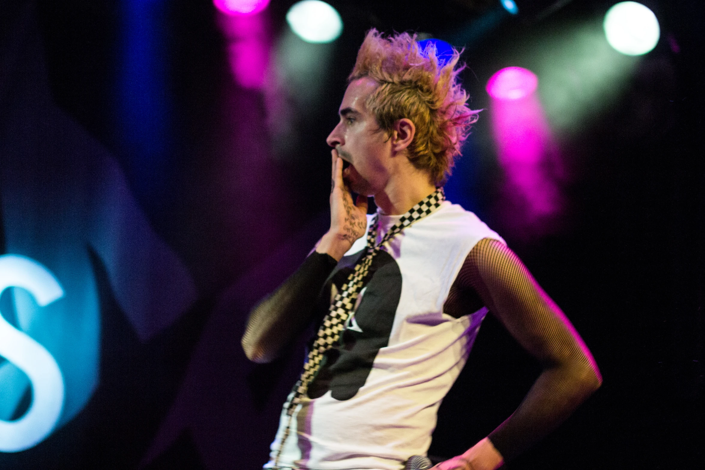 an attractive young person with a tie standing on a stage