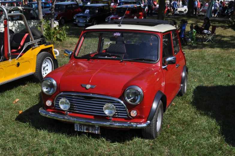 an old and new style car parked in the grass