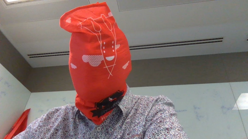 a man in a red bag covering his face