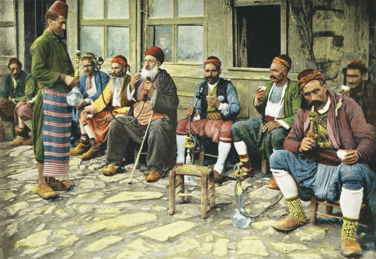 a group of men sitting on the side of a building with boots