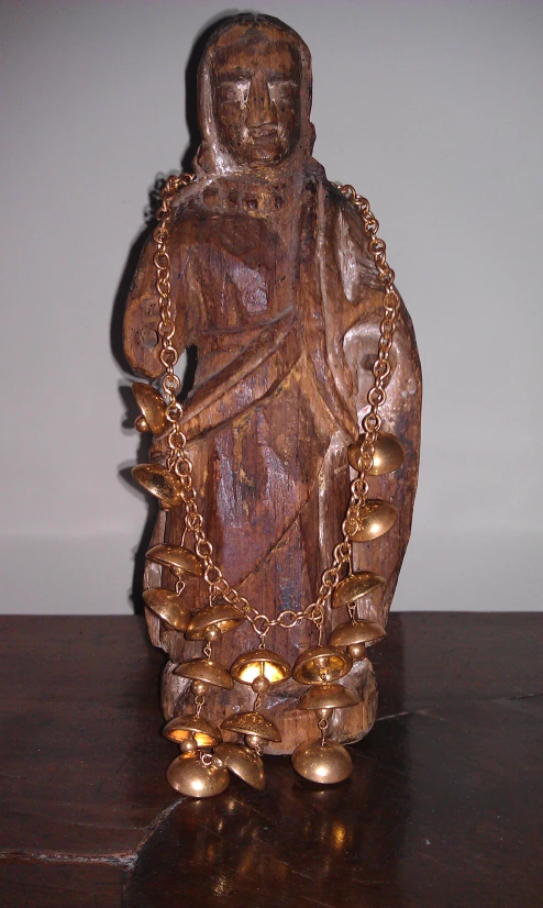 wooden statue of a buddhist god with metal beads