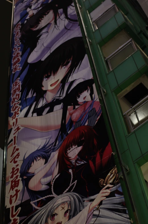 poster on building with anime characters hanging in front