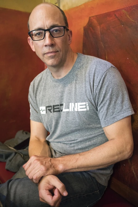 a man with glasses sitting on a bench