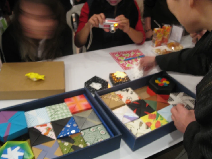 several people gathered at a table with boxes and paper work