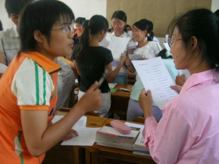 people standing in a classroom full of desks