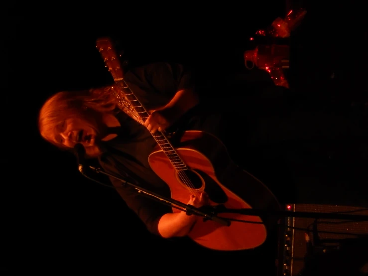 the man is playing his guitar on stage