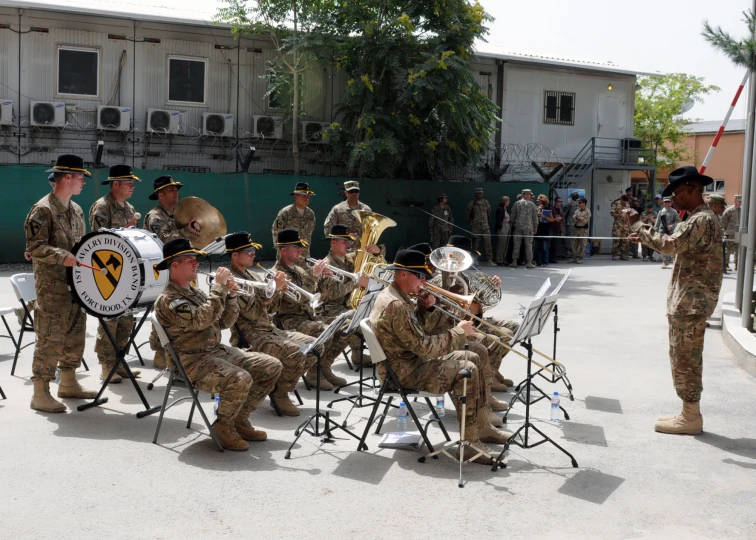 military men in uniforms playing instruments while others watch