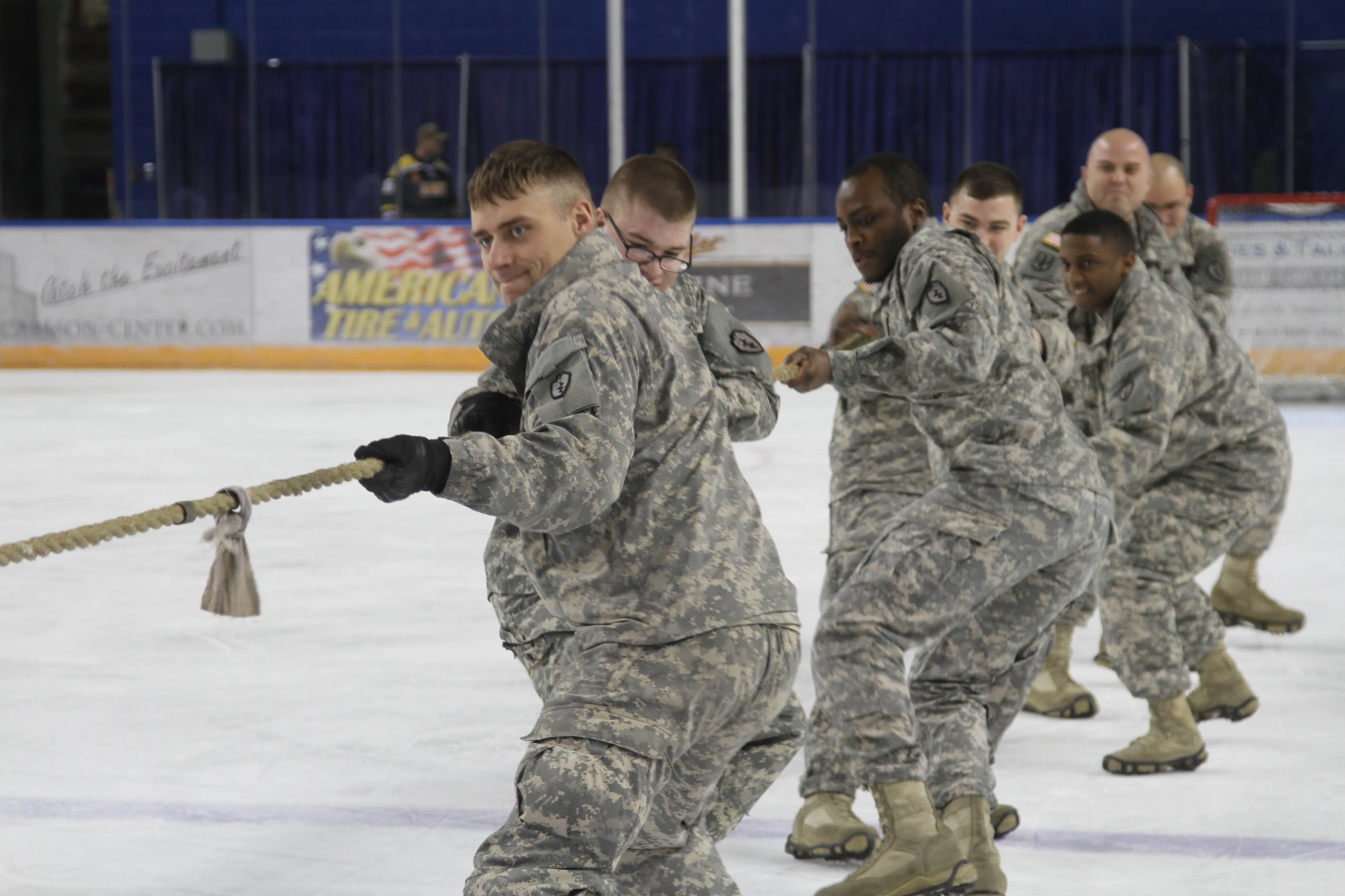 military men in uniform pulling on rope in ice