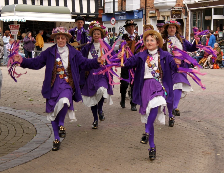 people dressed in purple walking down the street