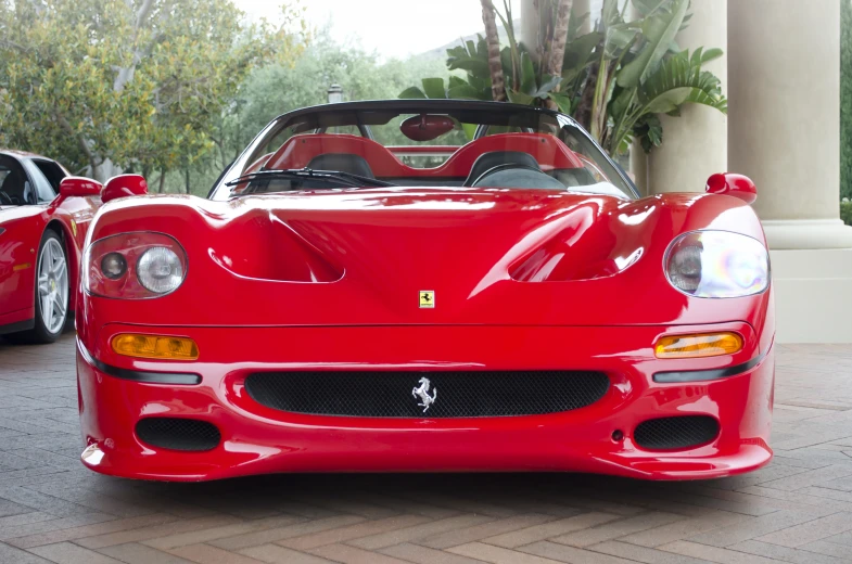 this is a very bright red sports car that's parked