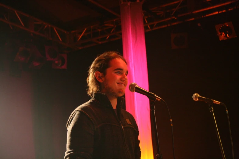 man stands in front of a microphone while singing