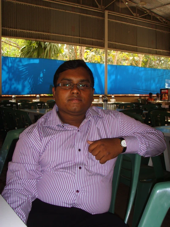 a man in purple shirt sitting on top of a table