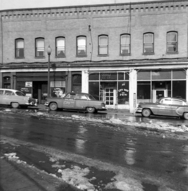 cars are parked outside a large brick building