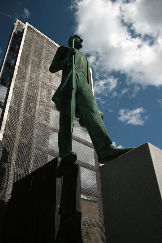 the statue of a man stands next to the fence