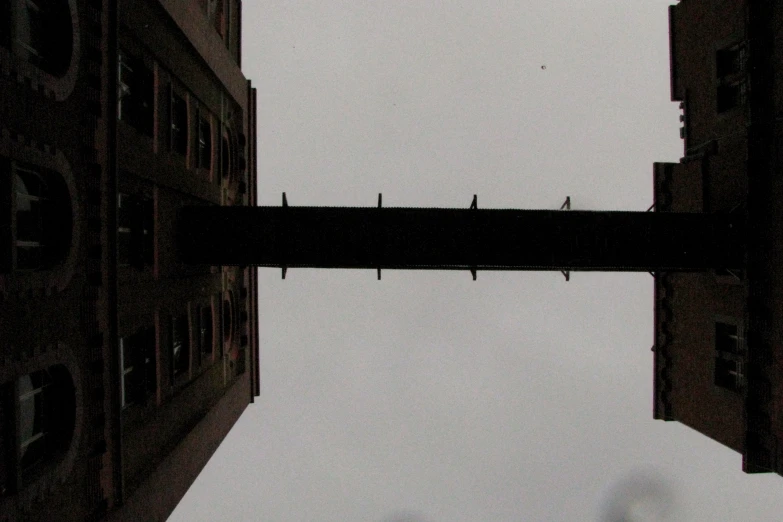 two birds are perched on the top part of a bridge