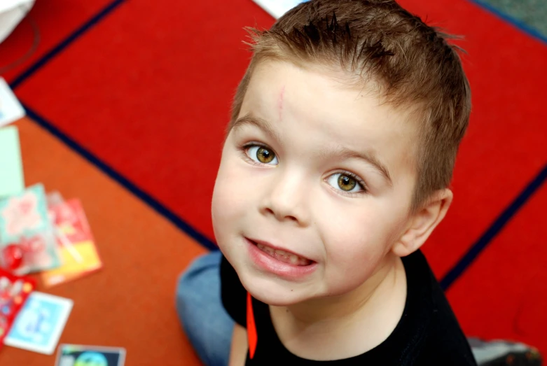 a boy has headphones on and looks up while looking at the camera