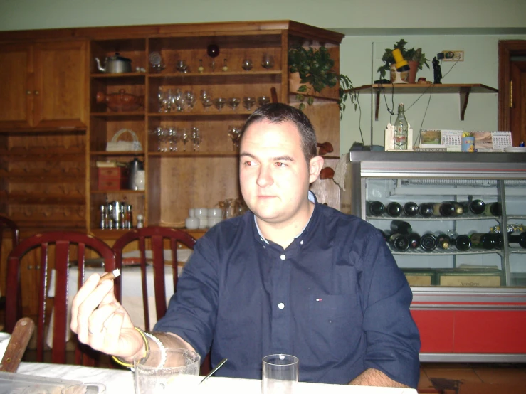 a man is sitting at a table with empty glasses