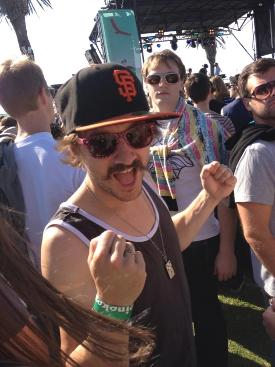 a man is standing on some grass wearing a hat