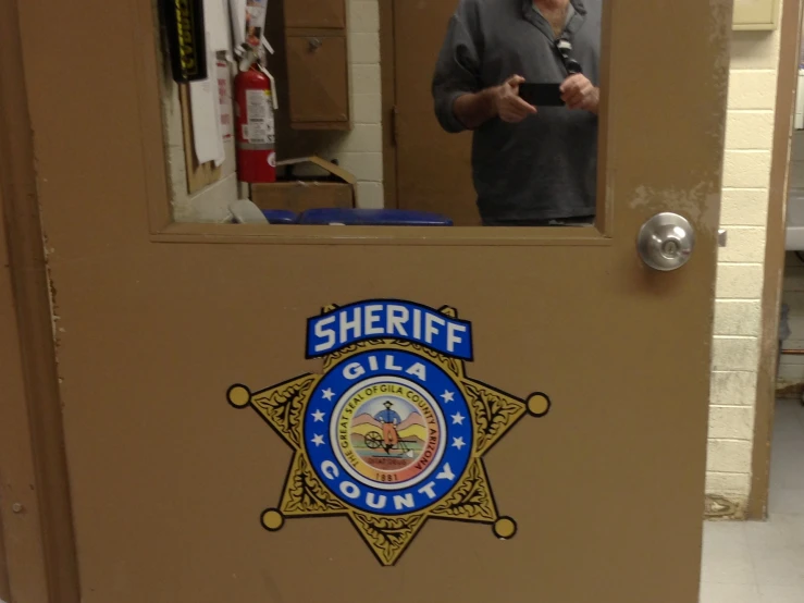 man standing by door in building behind glass