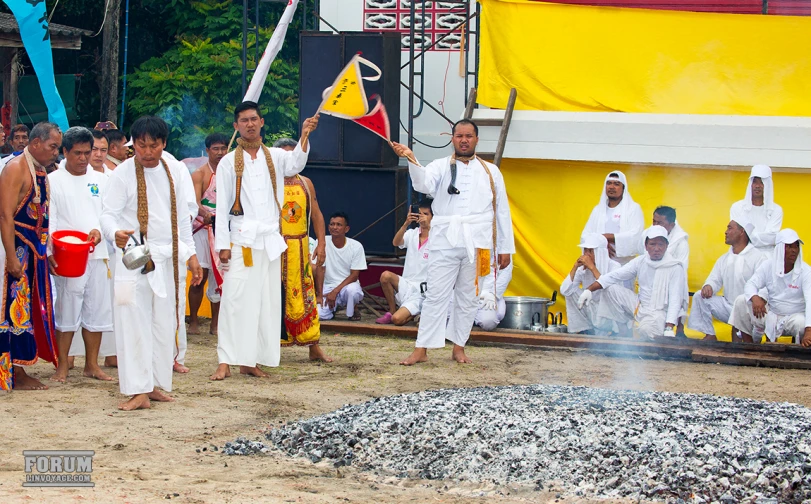 men in white standing and talking on a stage with other people