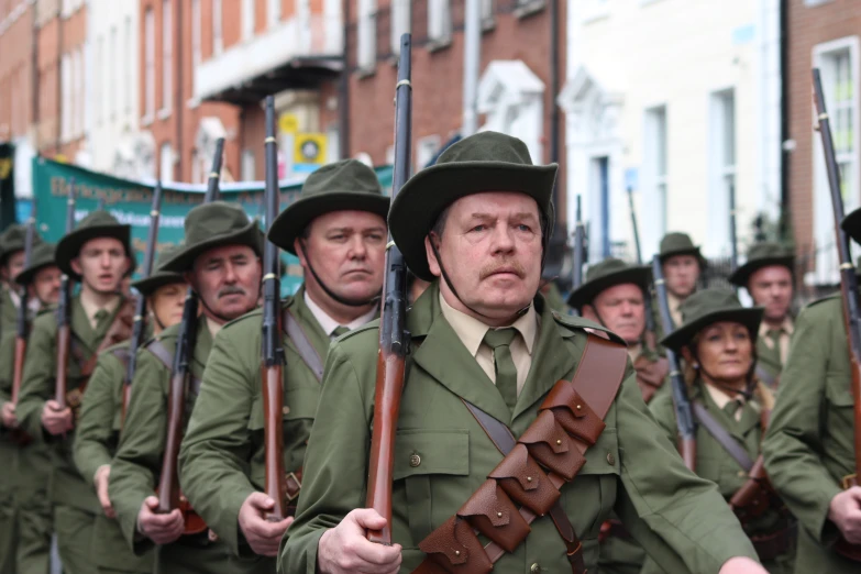 several soldiers are in uniform marching down a street