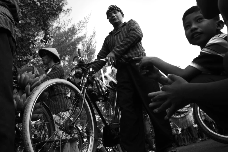 a group of men and boys standing around with their bikes