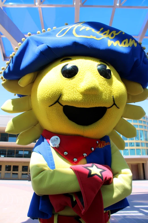 a yellow stuffed animal dressed as an officer with his arms crossed