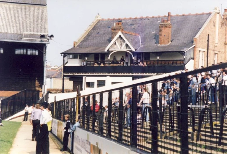 a group of people standing on a fenced in area