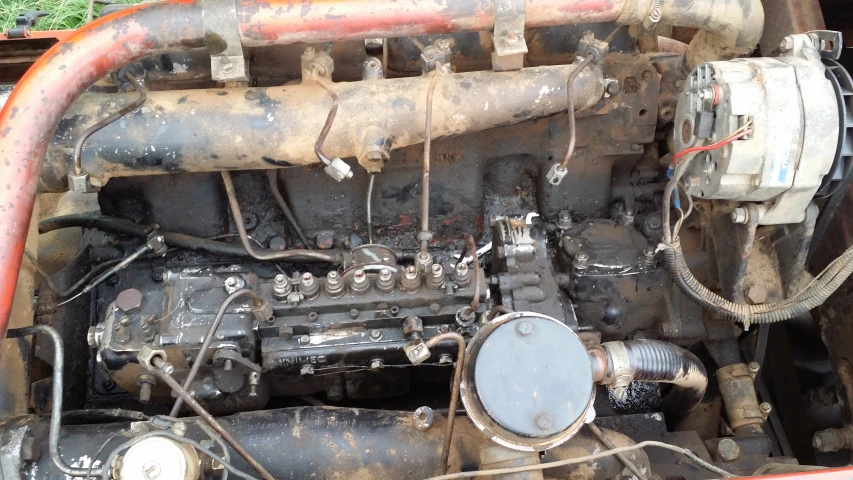 an old red and black engine with a number of switches and gauges on the valve cover