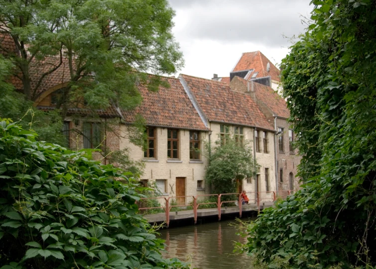 a house with windows and shutters over a waterway