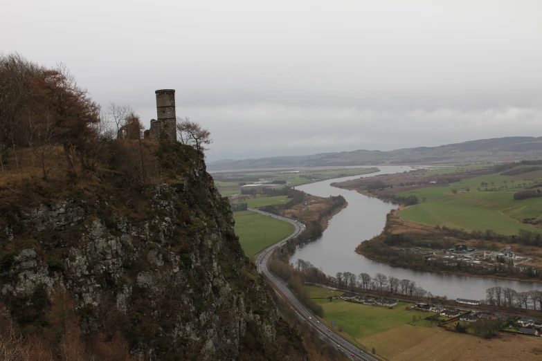 a very tall cliff sitting on the side of a river