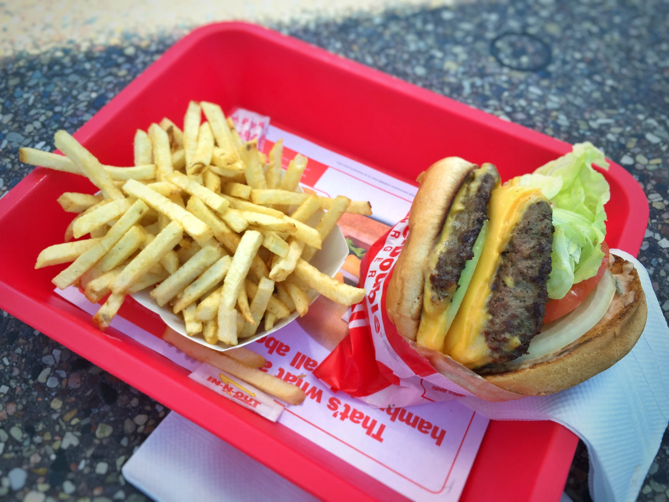 a red tray with a large burger and fries