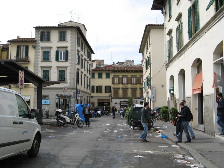 the street is littered with garbage as people walk in it