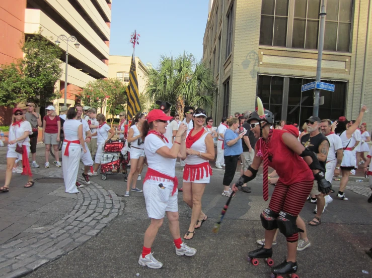 a parade with men and women on rollers and some dancers