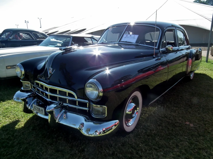 an old car is displayed in a park setting