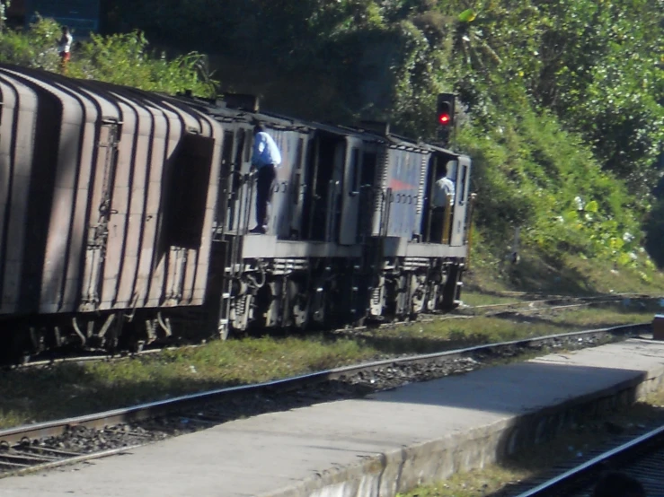 two freight cars driving on a track in the sun