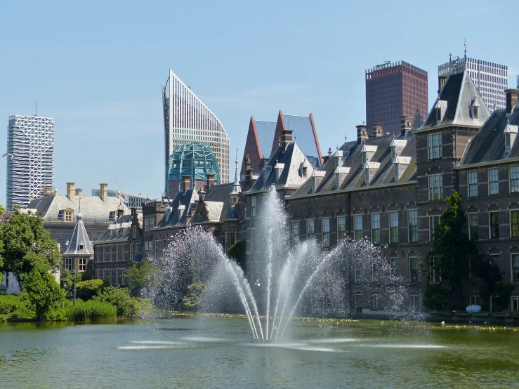 a building is in the distance with a water fountain in front of it