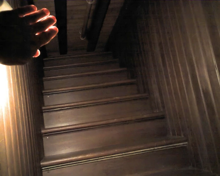 a person holding their hand against the top of the stairs