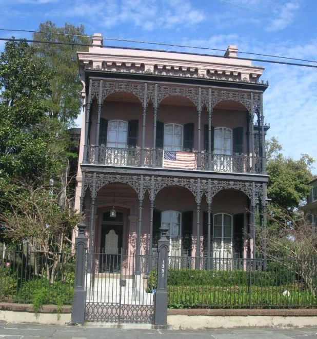 a pink house is sitting by the side of the street