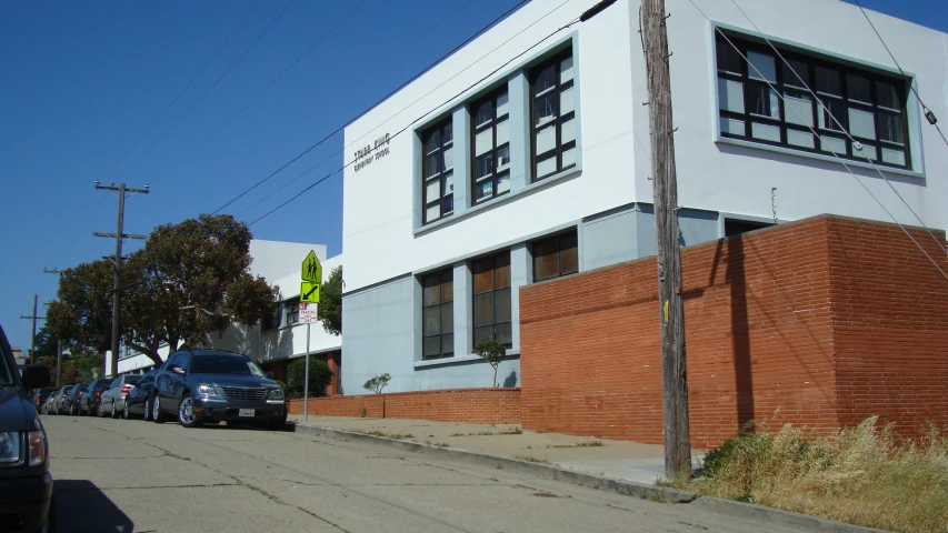 some cars are parked along a curb on a clear day