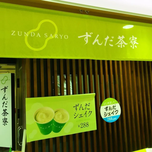 a yellow sign above a window stating the japanese food company zunda sasayo