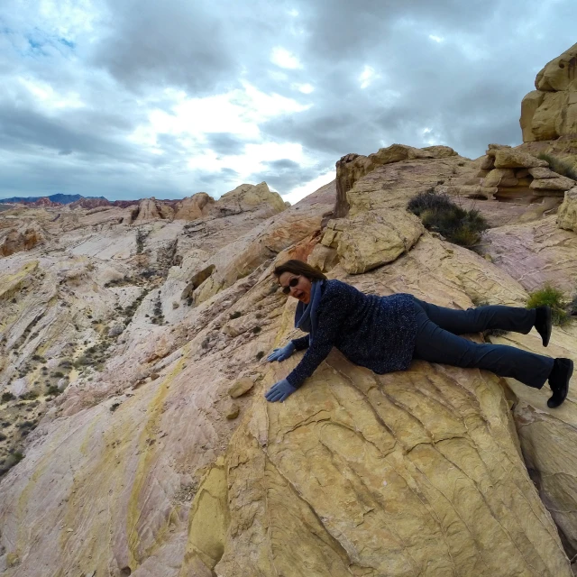 a woman on top of a rock with her legs crossed