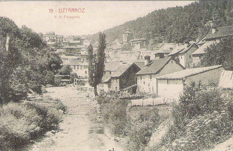 a street and houses on a hill with trees