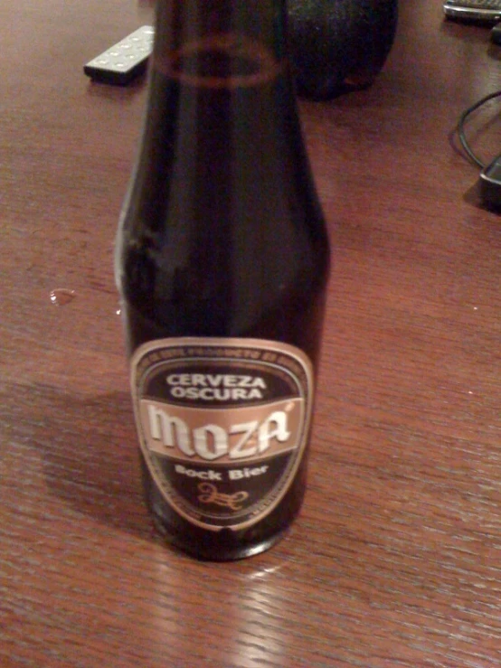 a bottle of beer sitting on top of a wooden table