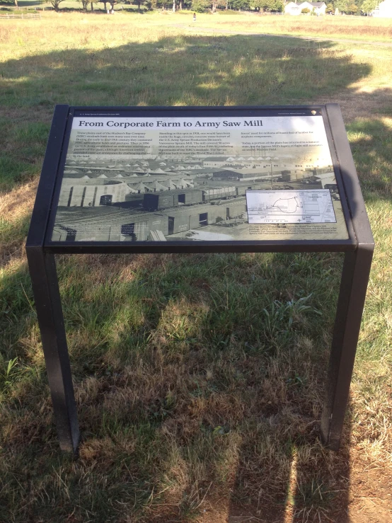 an information sign sitting in the middle of a field