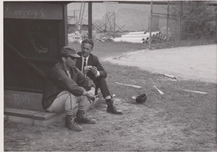 the two men are sitting on the steps outside