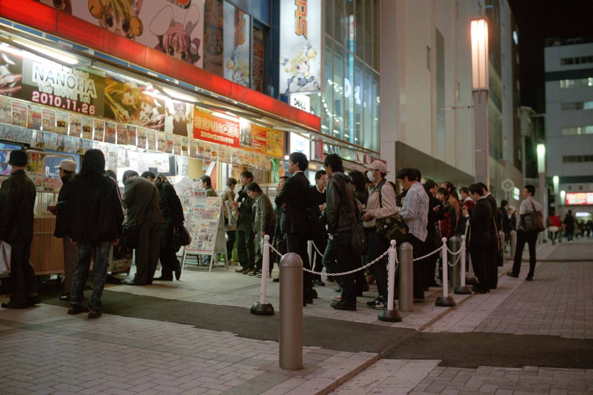 a group of people stand outside of a store at night