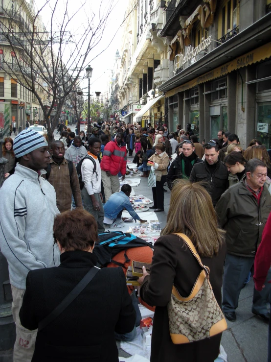 a street is busy with shoppers as well as pedestrians