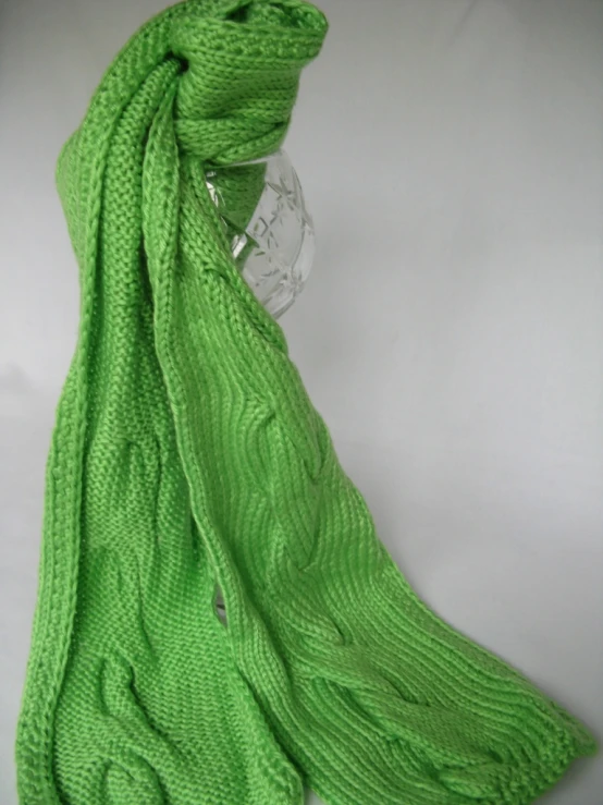 a green knitted blanket laying on top of a table