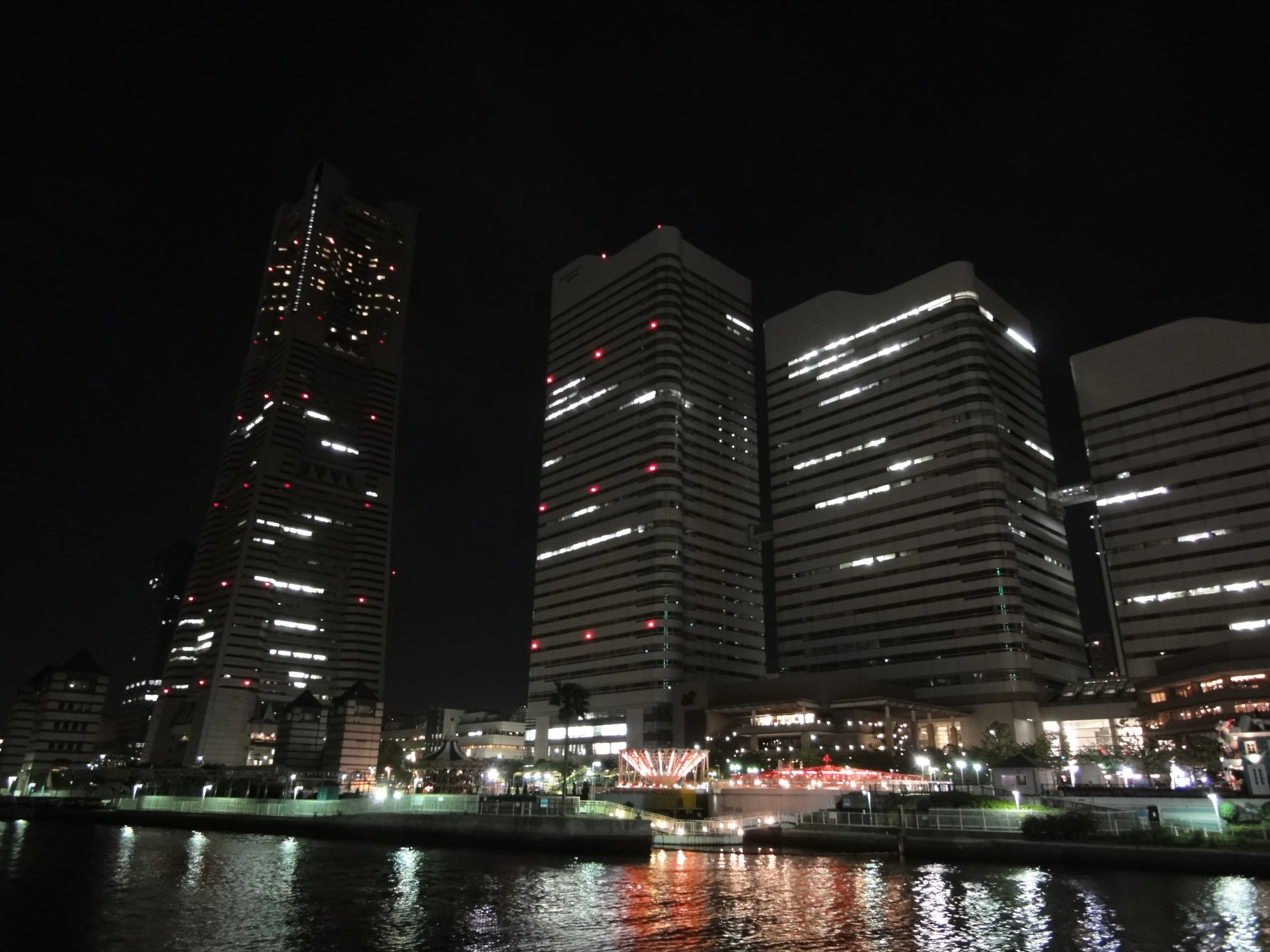 some very tall buildings by some water at night